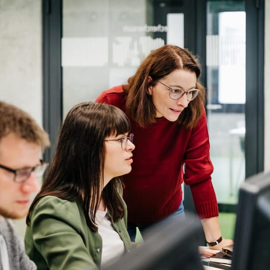 Two women looking at a computer in a working environment 