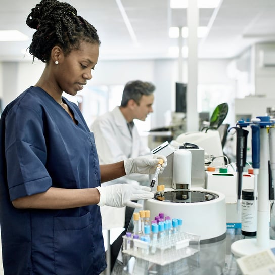 Pathology technician in blue scrubs in laboratory test