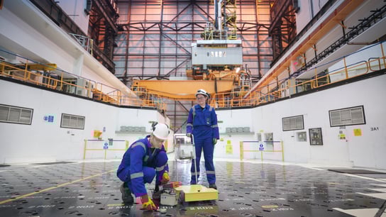 Engineers using sensors on pile cap in nuclear power station.
