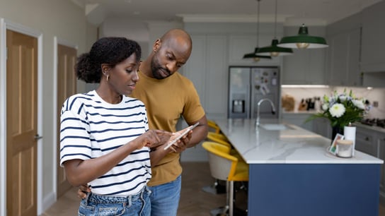 African American couple controlling their smart home using a mobile app on a tablet