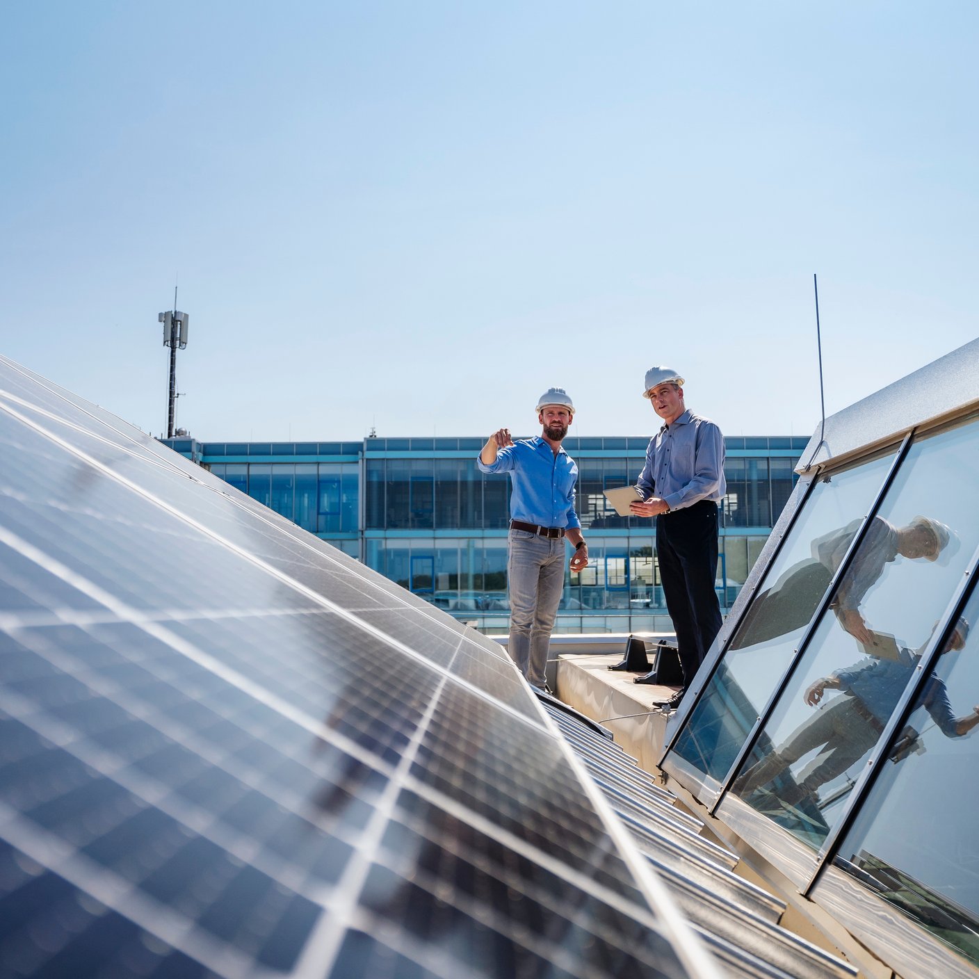 2 man standing next to solar panel 