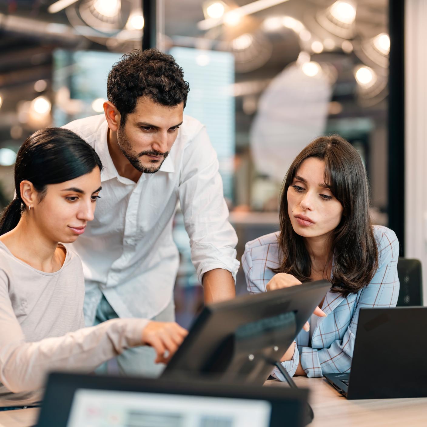 Small group of co-workers working together in a startup business office space.
