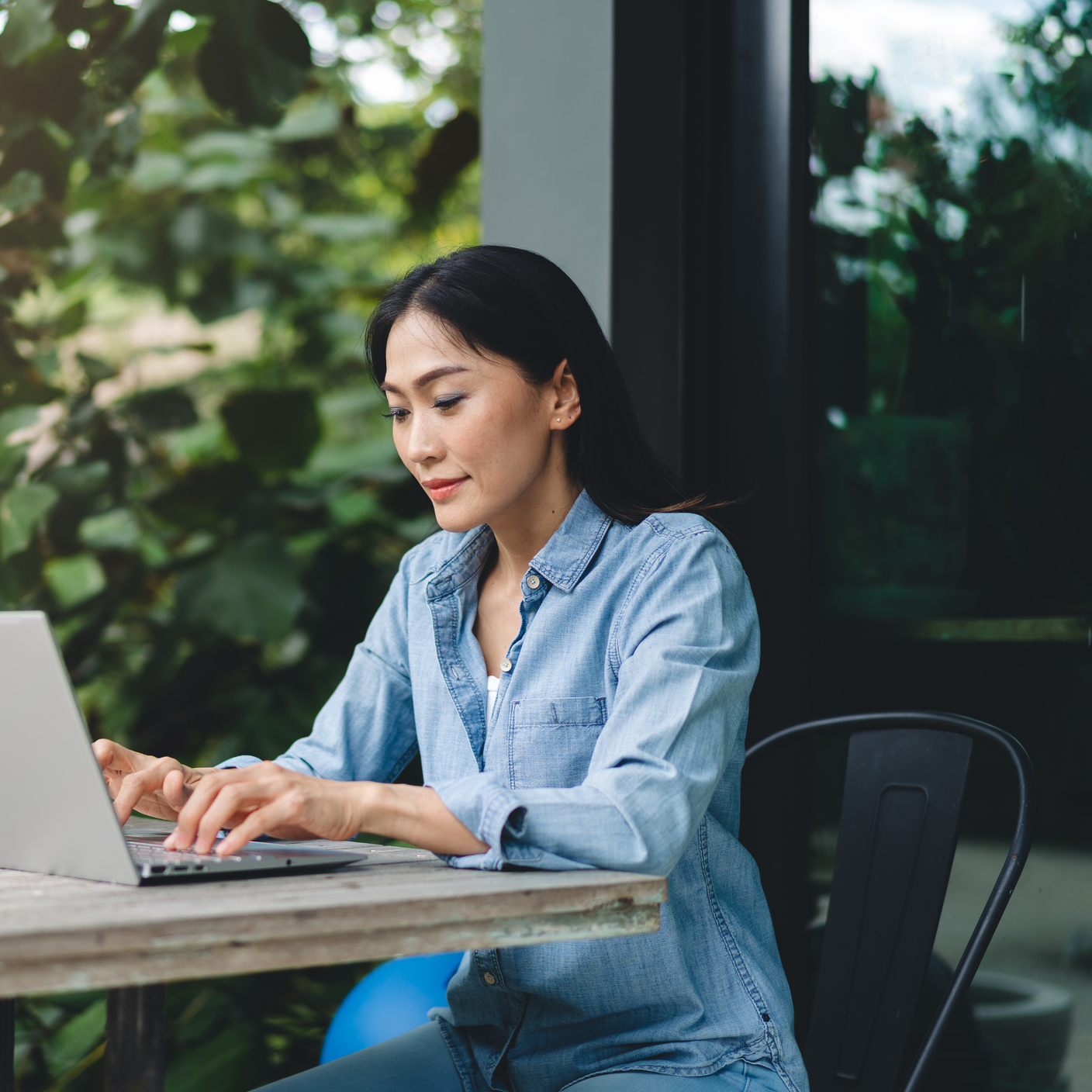 Happy Asian female using laptop working outdoors, web conference, remote work concept.