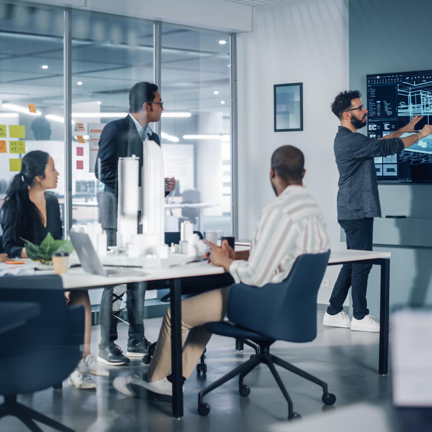 Riunione in uno studio di architettura multietnico moderno. Gruppo di architetti professionisti, designer