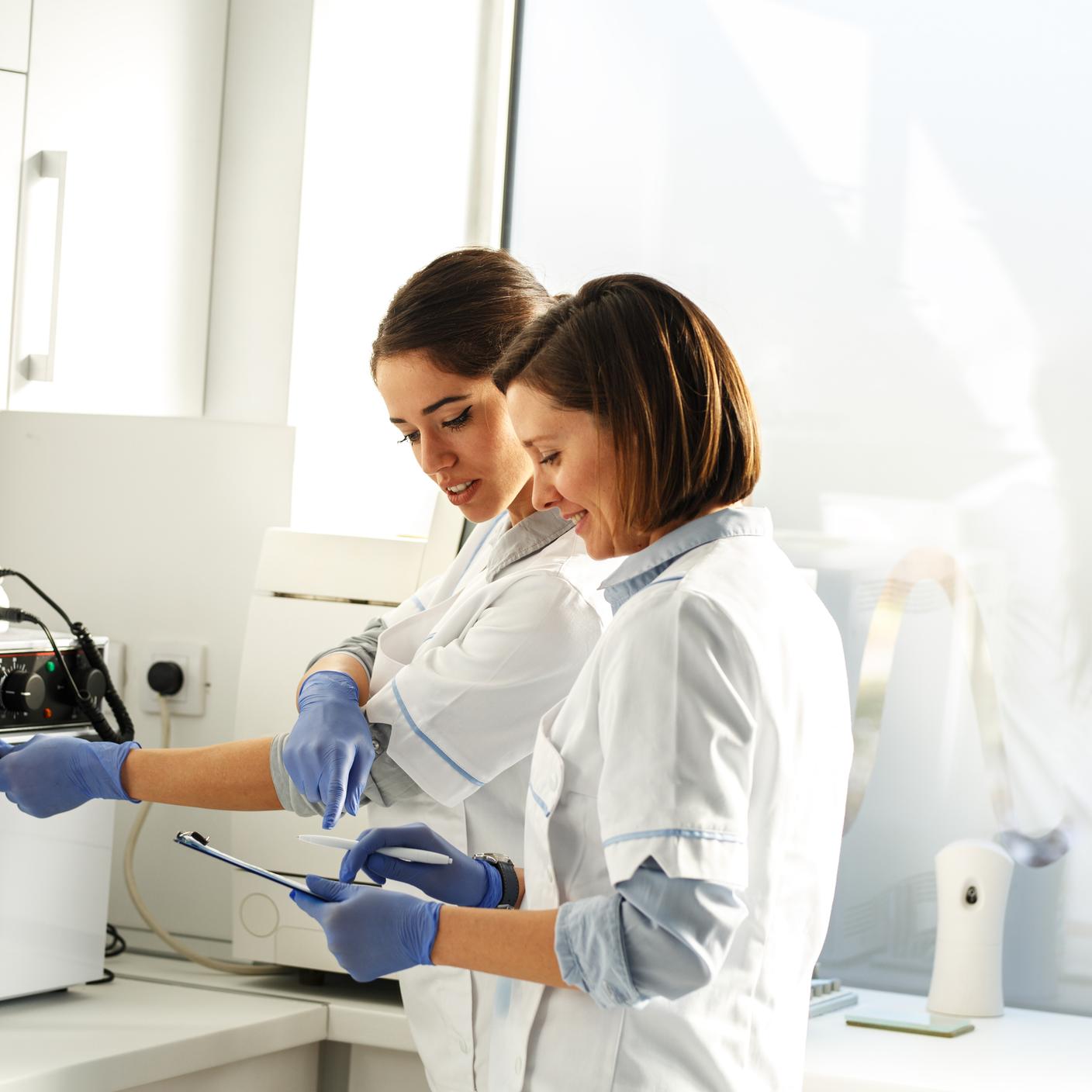 Female dentists in a dental office, cleaning equipment for next working day.