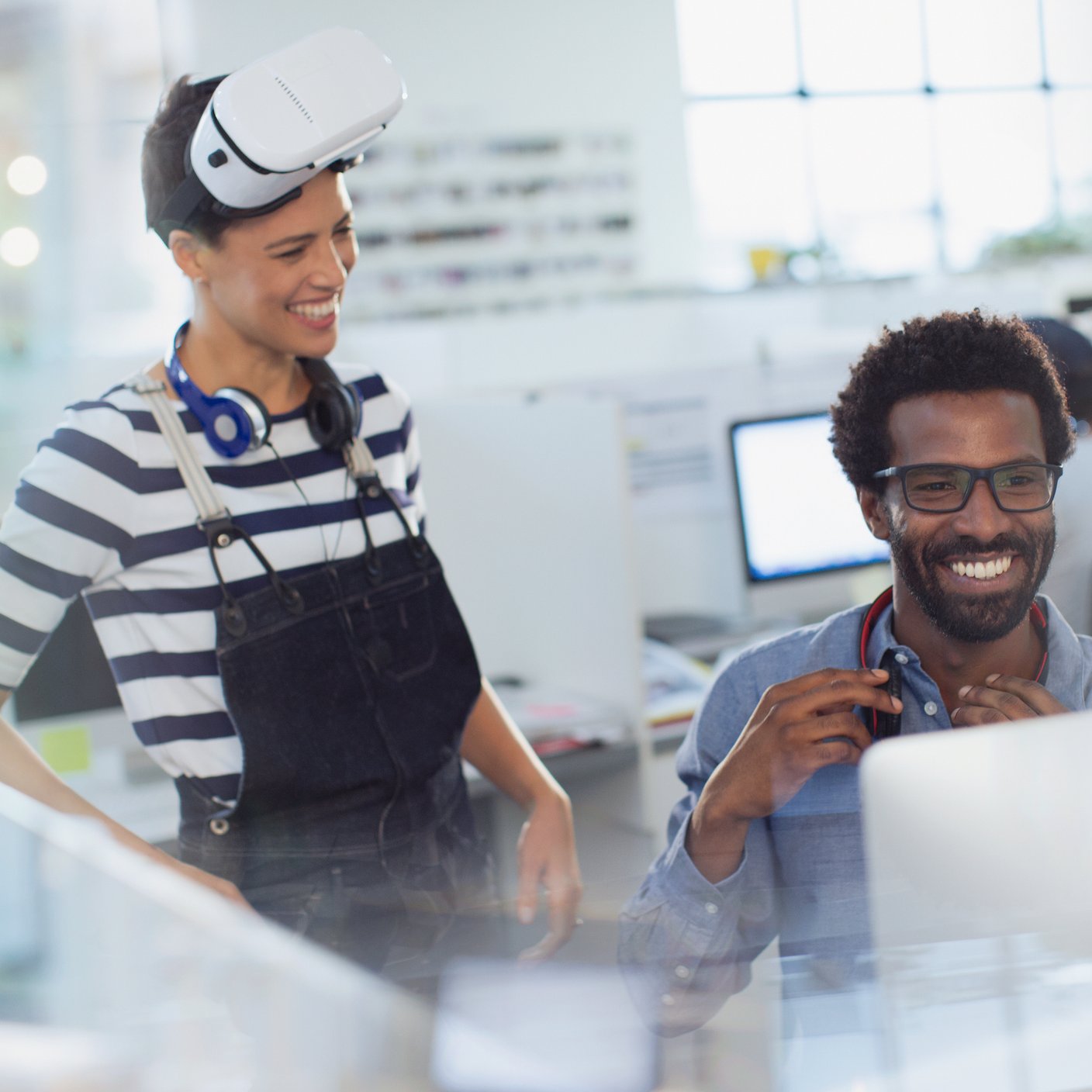 Smiling computer programmers programming virtual reality simulator in office