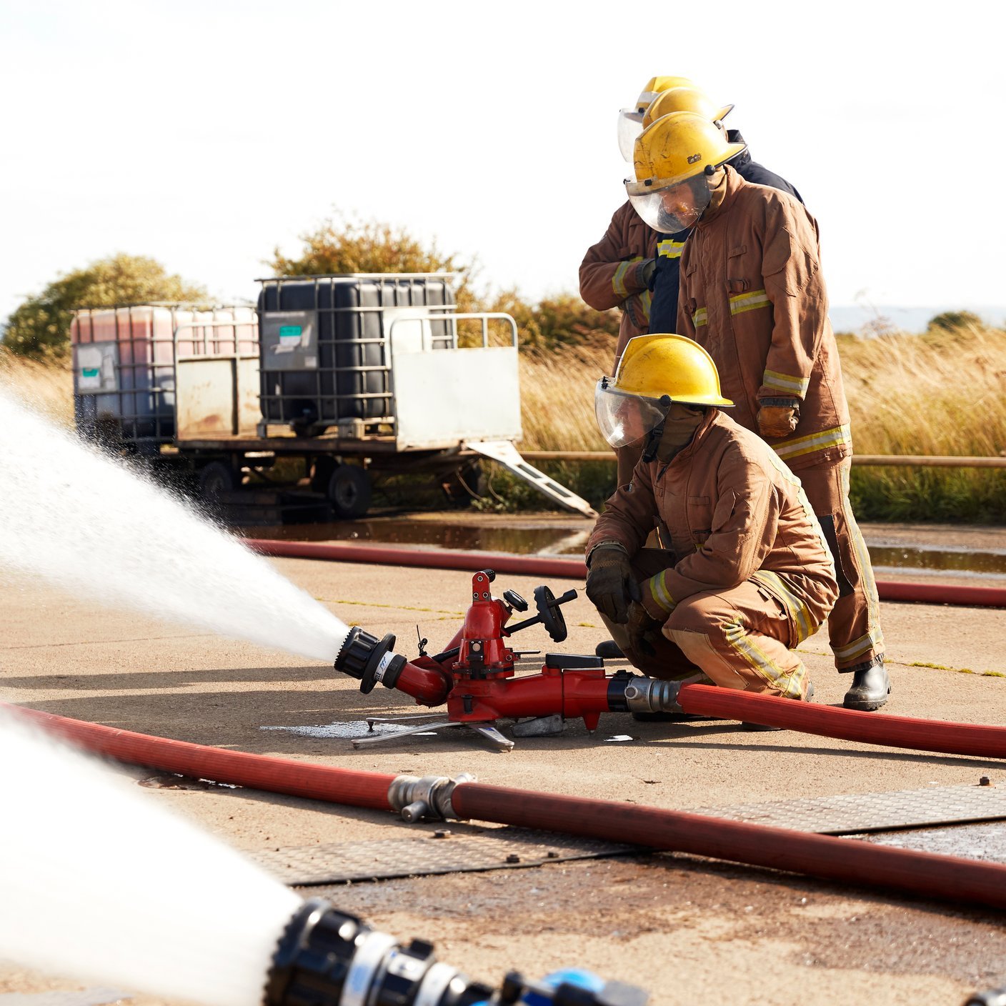 Two firefighters using fire hoses