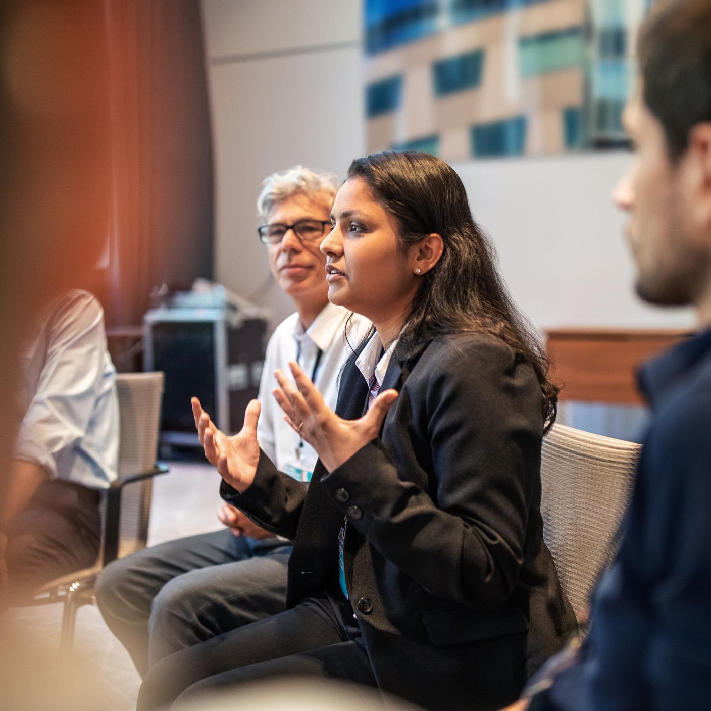 Une cadre s’entretenant avec des collègues lors d’une réunion dans un centre de congrès.