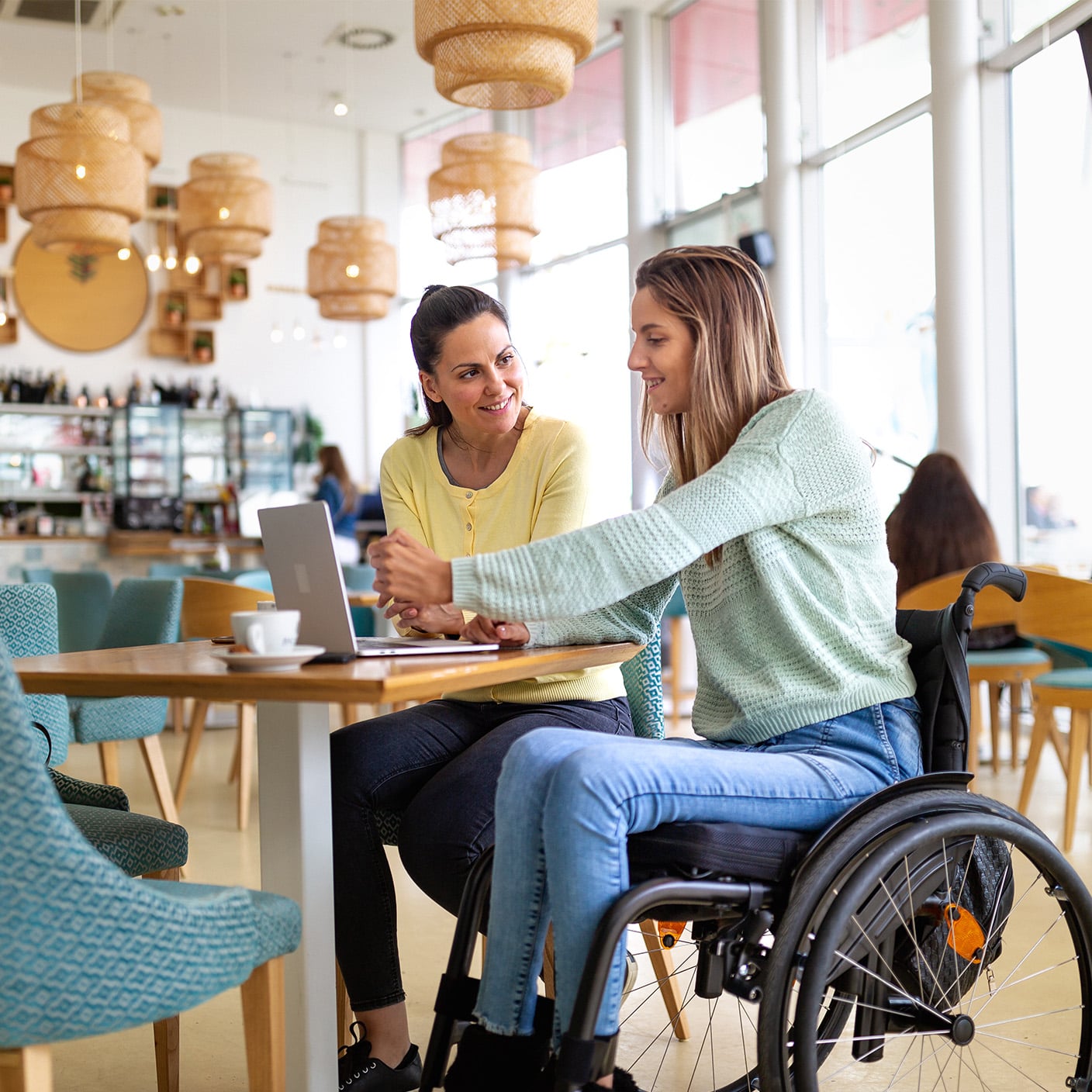 Women in wheelchair looking at laptop 