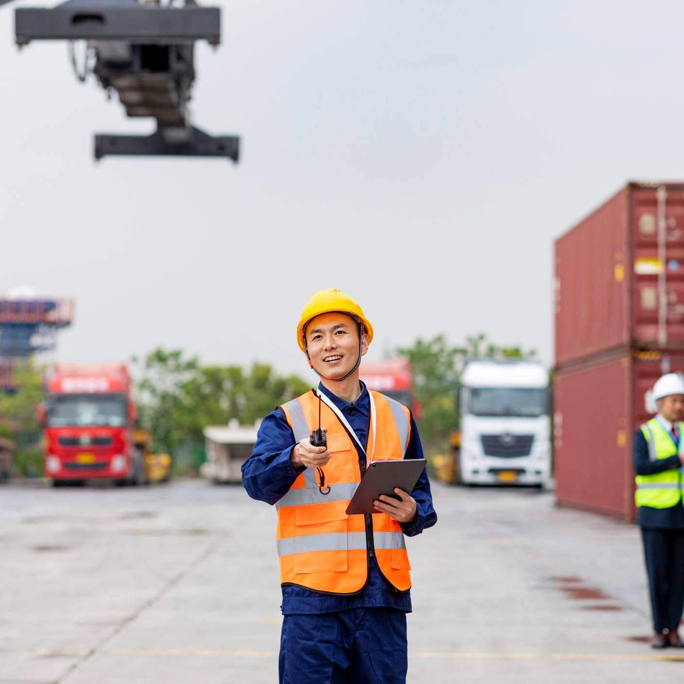 Male shipping control engineer standing in front of cargo container.On-time delivery and Customer Satisfaction of the key. Freight forwarder business concept. Outdoor working operating and control shipment at loading dock.