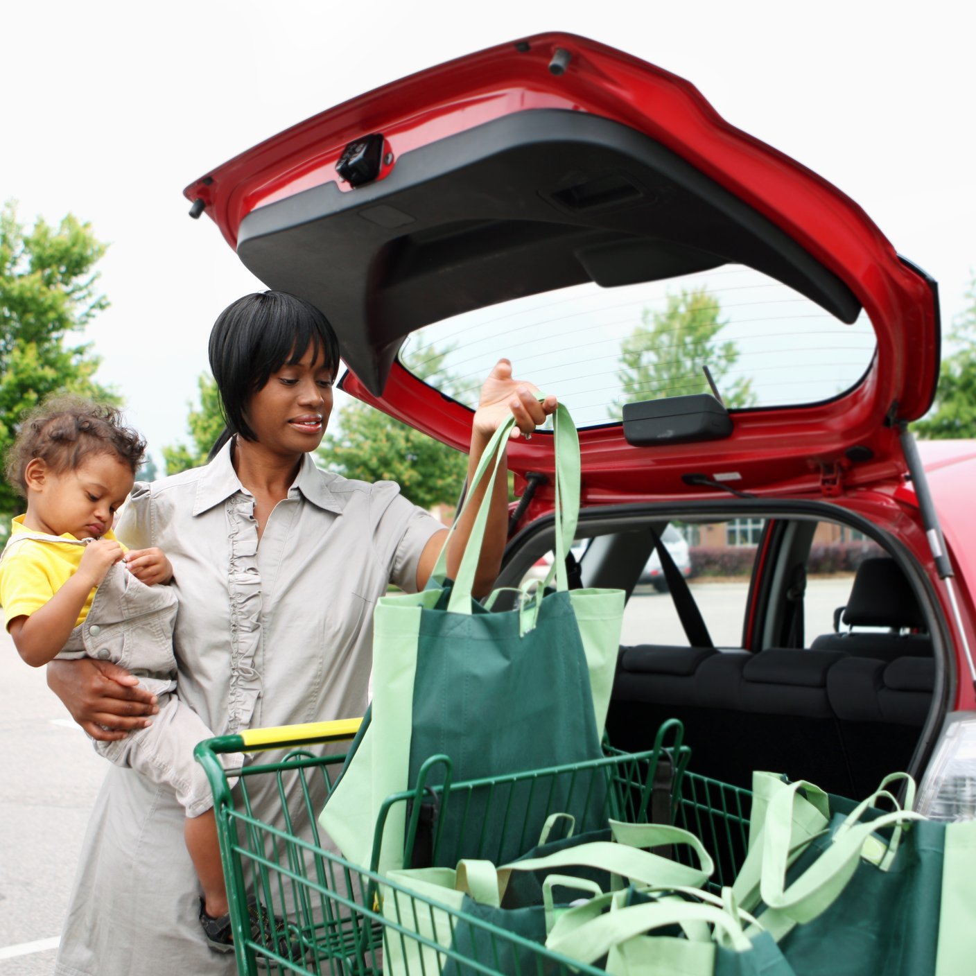 Mother and daughter packing boot of car.