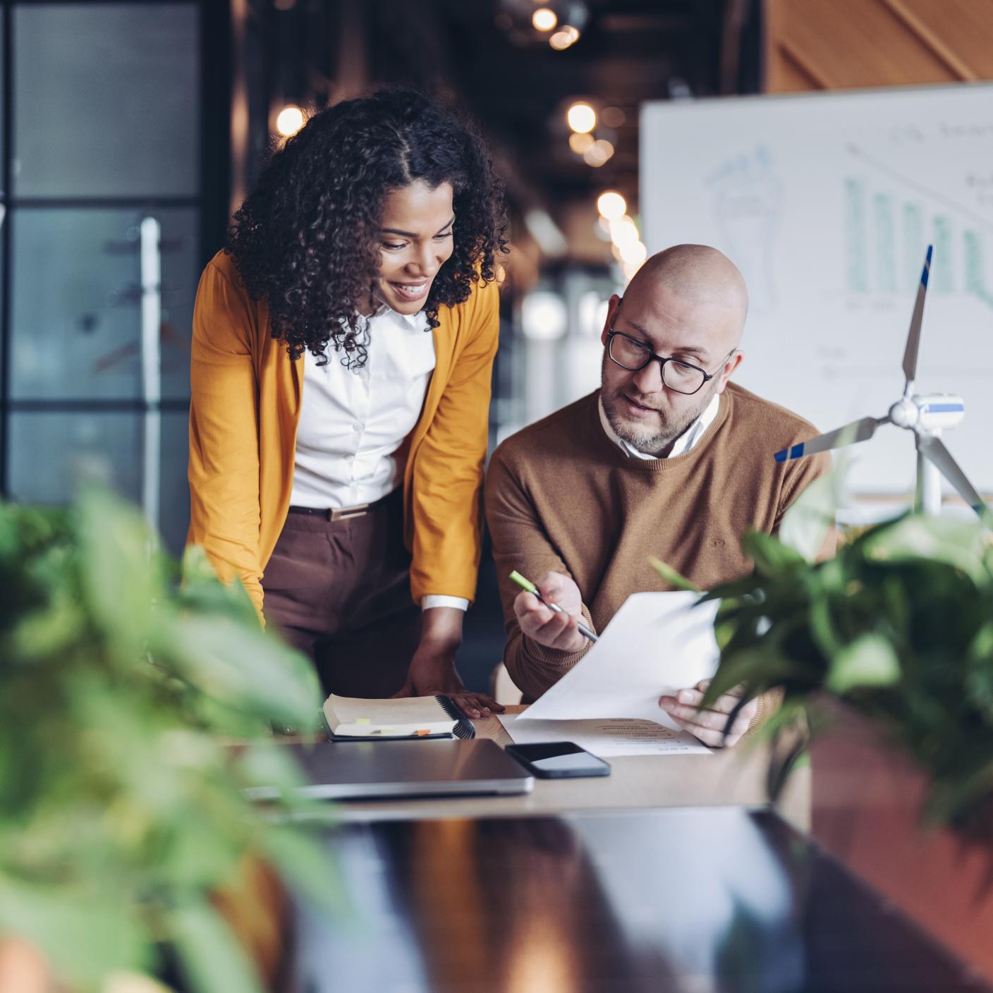 Two business persons talking in a modern green office