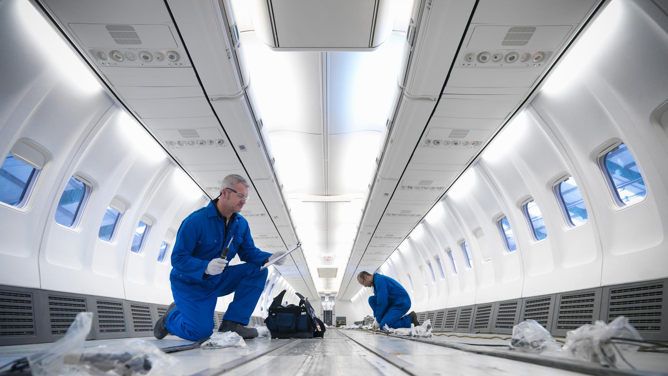 Aircraft engineers working on interior of 737 jet airplane