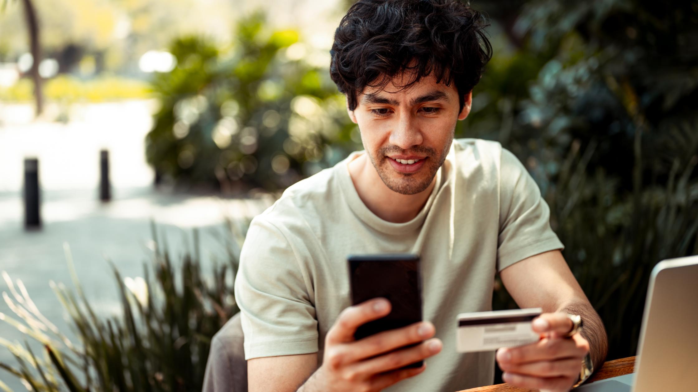 Man using his mobile phone to pay online with credit card.