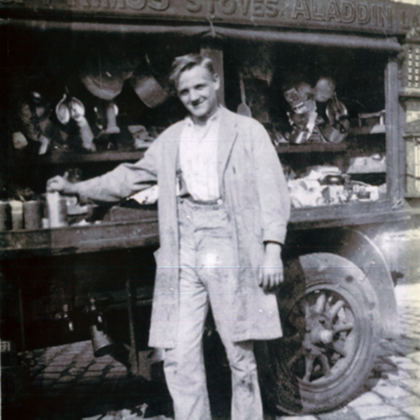 Black and white of man in front of market.